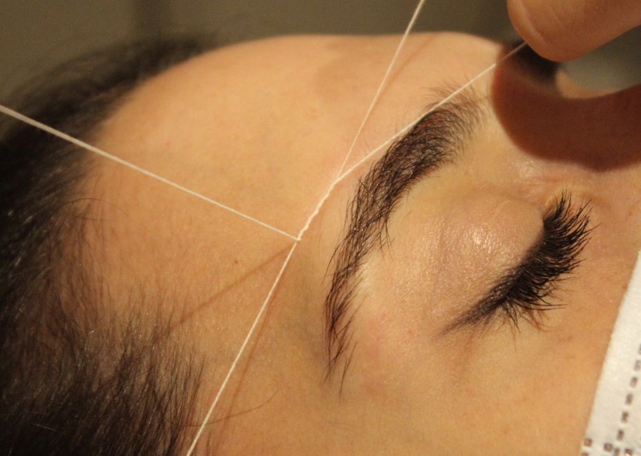 Eyebrow waxing with thread or tweezers